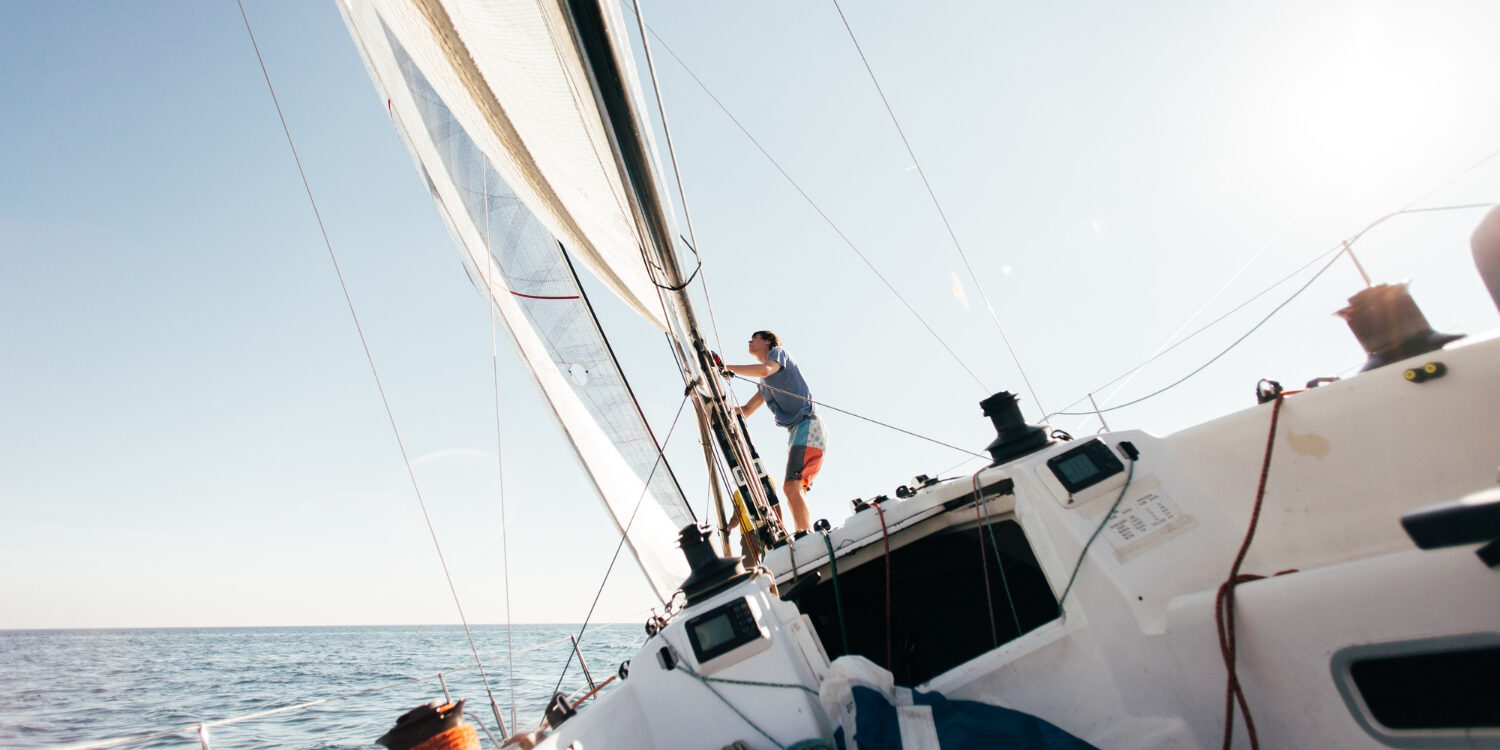deck-professional-sailboat-racing-yacht-during-competition-sunny-windy-summer-day-moving-fast-through-waves-water-with-spinnaker-up